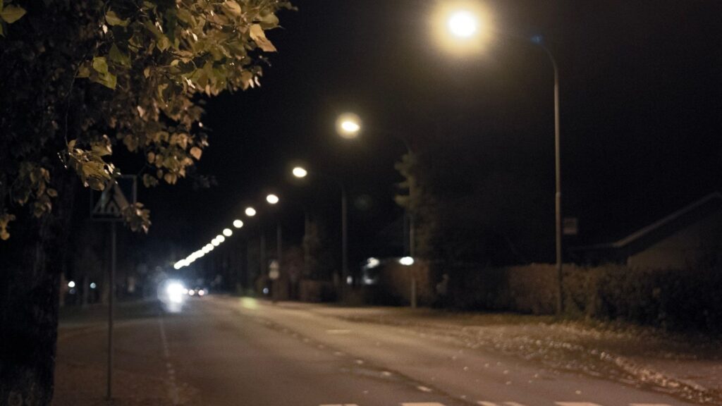 Pimeä katu ja katuvaloja.